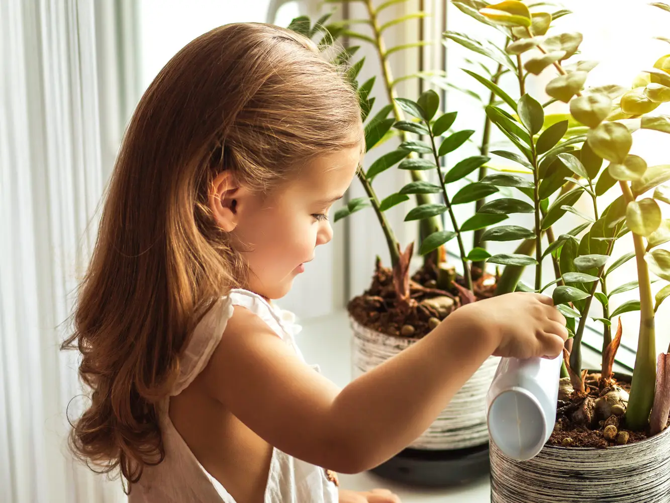 Kind Mädchen gießt Blumen Montessori Ausbildung Kopie